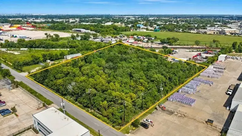 Aerial view of a wooded commercial land parcel outlined in southeast Houston, Texas